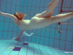 UhBabe presents: Redhead goes for a nude swim in the pool